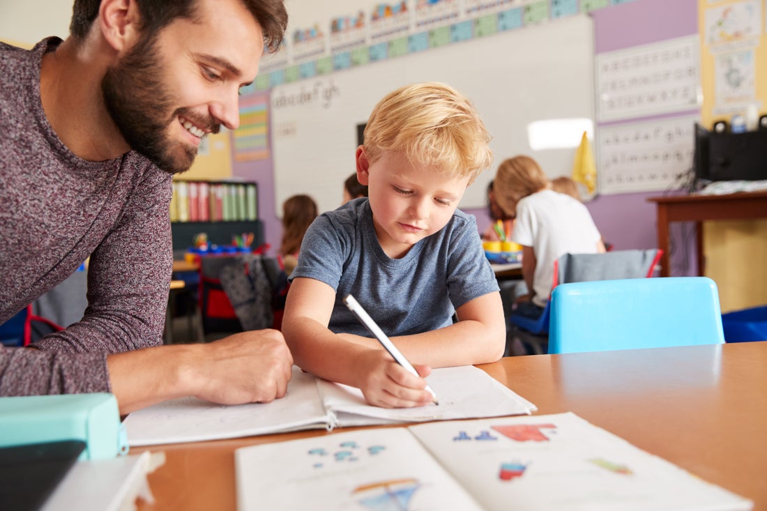 teacher helping student at their desk