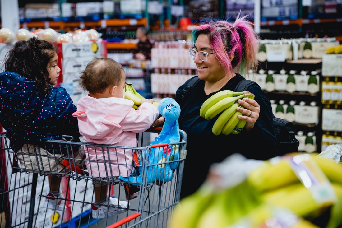Mom grocery shopping with her children.