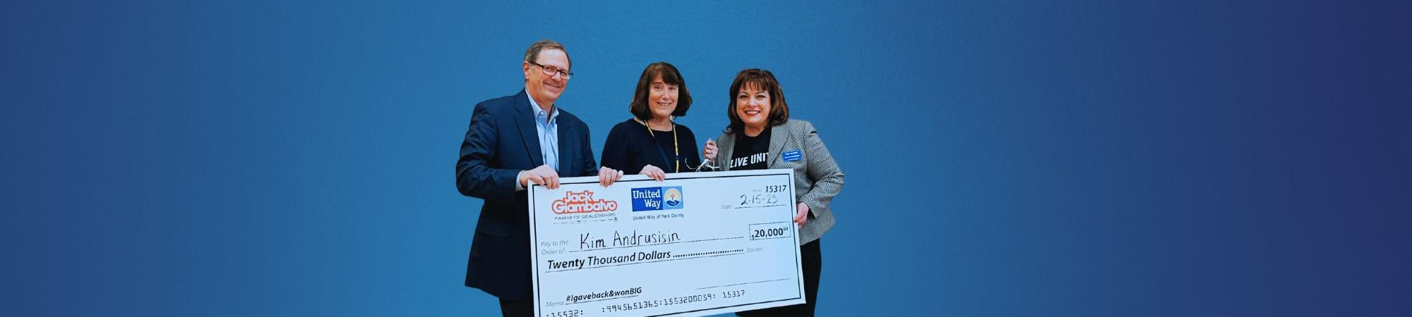 Three people holding giant prize check