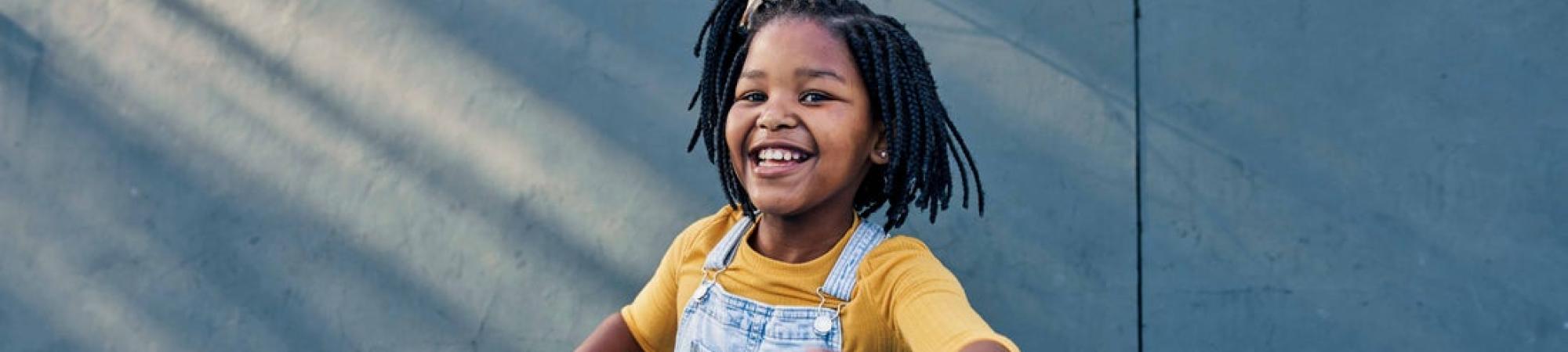 Girl hula hooping and smiling.