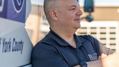 man leaning against the bus he drives