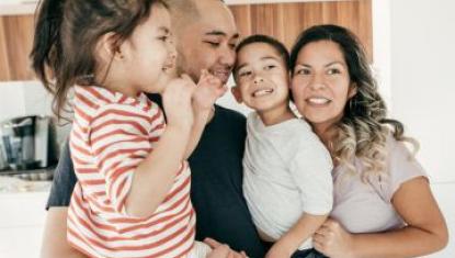 A family of four standing together posing for a camera