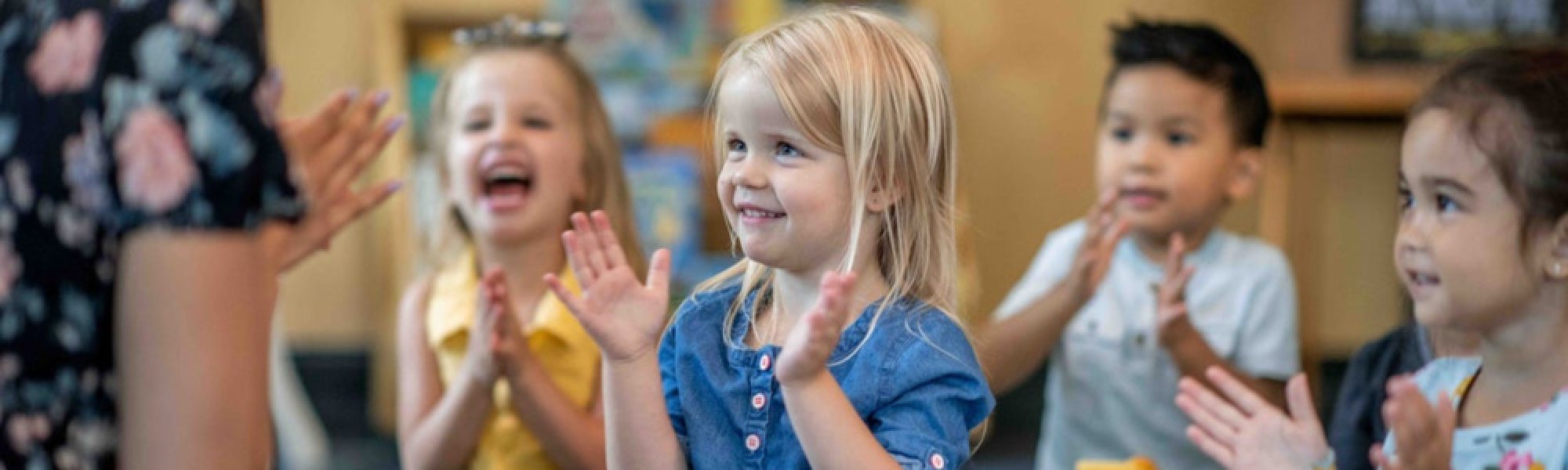 Children clapping with their teacher.